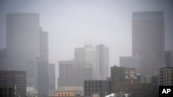 A light snow shrouds the skyline as a winter storm sweeps over the intermountain West, Jan. 18, 2025, in Denver.