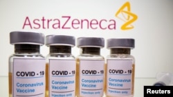 Botol dengan stiker bertuliskan, "Hanya COVID-19 / vaksin Coronavirus / Injeksi" dan alat suntik medis terlihat di depan logo AstraZeneca yang terpampang di ilustrasi ini. (Foto: Reuters/Dado Ruvic)