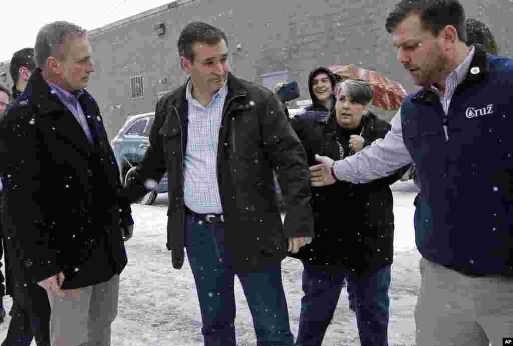 Kandidat capres dari Partai Republik Ted Cruz, tengah, berjalan dengan stafnya menuju bis setelah kampanye, 8 Februari 2016, di Manchester, N.H.