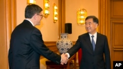 លោក​​ Jack Lew​ រដ្ឋមន្ត្រី​ក្រសួង​ហិរញ្ញវត្ថុ​ស.រ.អា.​ ចាប់​ដៃ​ជាមួយ​​ឧបនាយក​រដ្ឋមន្ត្រី​ចិន​​ Wang Yang នៅ​ខណៈ​លោក​បាន​មក​ដល់​ទីក្រុង​ប៉េកាំង​ដើម្បី​ជួប​ប្រជុំ​នៅ​ឯ Zhongnanhai Leadership Compound កាលពី​ថ្ងៃទី​៣០ ខែ​មីនា ឆ្នាំ២០១៥។