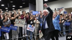 លោក Bernie Sanders ដែល​កំពុង​លើក​ដៃឡើង​ទៅ​លើ​ ឈ្នះ​ភ្លូកទឹកភ្លូកដី​នៅក្នុង​រដ្ឋ Washington រដ្ឋ Alaska និង​រដ្ឋ Hawaii។