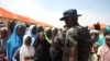 Un personnel de la sécurité fait signe aux réfugiés du camp de Bakkasi pour les déplacés internes après une manifestation contre les rations de nourriture trop petites, à Maiduguri, dans l'État de Borno, Nigeria, le 29 août 2016. 