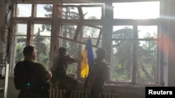 Українські військові встановлюють прапор на будівлі під час операції зі звільнення першого села в ході контрнаступу у Благодатному Донецької області/ REUTERS