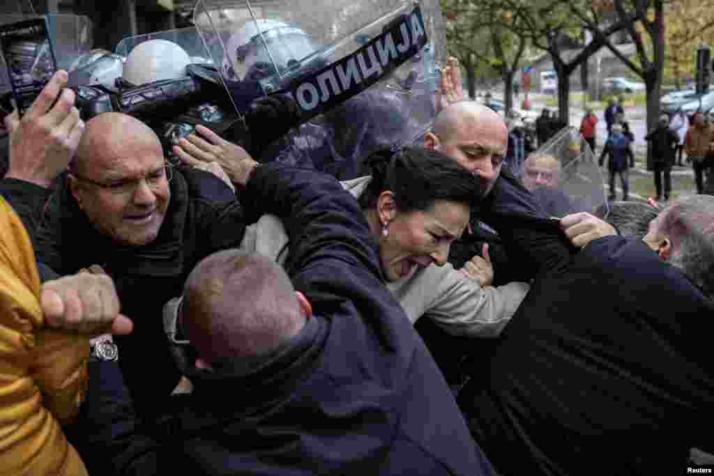 Serbian members of parliament Marinika Tepic and Borislav Novakovic, and other opposition representatives scuffle with police officers during a protest over the fatal collapse of a roof at a railway station, demanding that those responsible for the disaster be brought to justice, in front of a court house in Novi Sad. 