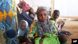 A family of refugees that fled their homes due to violence from the Islamic extremist group Boko Haram sit inside a refugee camp in Minawao, Cameroon, Feb. 25, 2015.