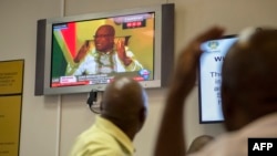 Para pengunjung menyaksikan penayangan televisi di Ruang Tamu Parlemen yang tengah menampilkan Presiden Jacob Zuma di Cape Town, 14 Februari 2018. 