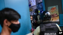 Miembros de la policía nacional ordenan al dueño de un negocio cerrar su tienda durante una cuarentena ordenado por el gobierno para frenar la propagación de COVID-19 en Caracas, el 21 de mayo de 2021.