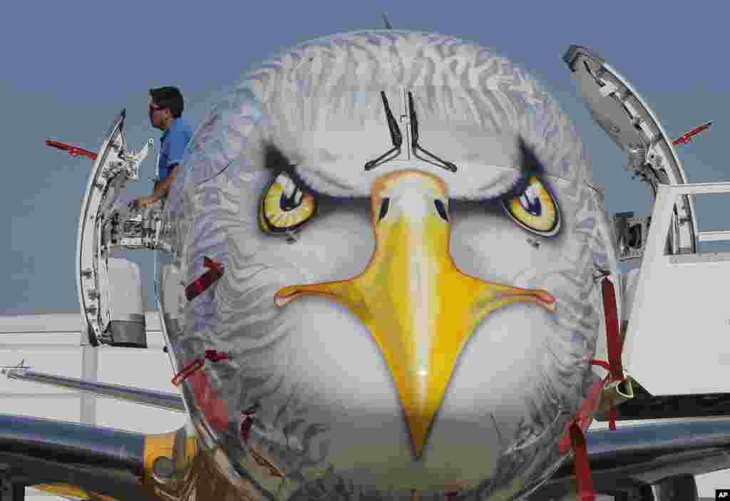 Seorang pria memandang keluar dari pintu purwarupa pesawat Embraer E195-E2, yang dikembangkan oleh perusahaan dirgantara Brazil, Embraer, di Paris Air Show, sehari sebelum pembukaan acara, di Le Bourget, sebelah timur Paris, Perancis.