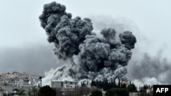 Une épaisse fumée, des débris et des flammes s’élèvent après une frappe aérienne de la coalition menée par les Etats-Unis à Kobani, en Syrie alors que des combats s’intensifient entre les Kurdes Syriens et des combattants de l’Etat Islamique, comme observé depuis les faubourgs de Suruc, à la frontière Turco-Syrienne, dimanche le 12 octobre 2014. (AP Photo/Lefteris Pitarakis)