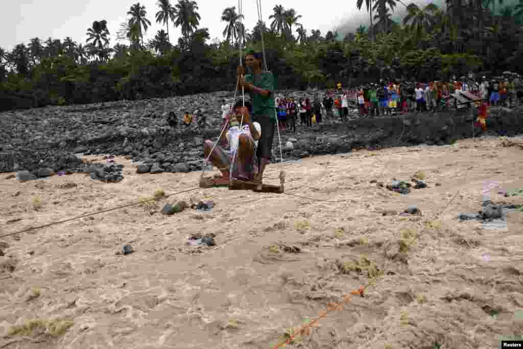 Warga menggunakan peralatan sederhana untuk mencapai pasokan bantuan pangan di kota Bataan, Filipina selatan yang dilanda banjir.