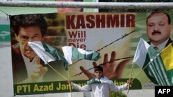 د پاکستان تر واک لاندې کشمیر کې یو ماشوم د کشمیر او پاکستان او بیرغونه په لاسونو کې نیولي دي