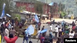 A still image taken from a video shot on October 1, 2017, shows protesters waving Ambazonian flags in front of road block in the English-speaking city of Bamenda, Cameroon. 