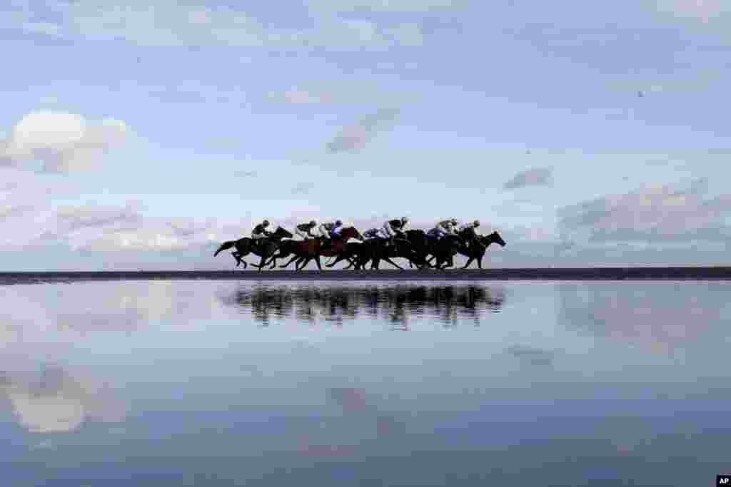 Runners and riders compete in the "Melbourne 10 Sorry We Can't Be There This Year Handicap" at Laytown racecourse, County Meath, Ireland.