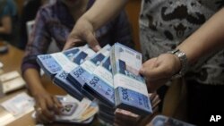 Seorang pegawai tempat pertukaran mata uang di Jakarta menghitung uang rupiah (Foto: dok).