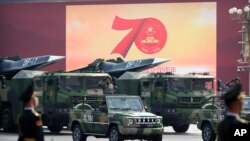 Turk-truk militer China membawa rudal balistik DF-17 saat parade memperingati 70 tahun berdirinya Komunis China di Beijing, Selasa, 1 Oktober 2019. Senjata yang dibawa termasuk rudal bersenjata nuklir. (Foto: AP)