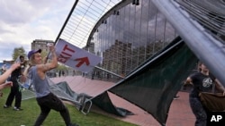 Manifestantes quitan barricadas que habían sido colocadas afuera de un campamento de protesta pro-palestinos en el Instituto de Tecnología de Massachusetts (MIT por sus siglas en inglés), el lunes 6 de mayo de 2024, en Cambridge, Massachusetts.