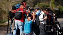 FILE - Honduran migrants get a ride on the back of a truck as they travel north in hopes of reaching the United States, in Quezaltepeque, Guatemala, Jan. 17, 2020. 