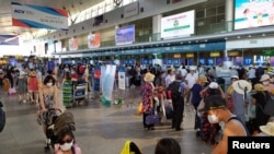 Tusristas nacionales usan máscaras en la zona hotalera de Da Nang, que se vio afectada en la última semana de julio de 2020 por un brote de coronavirus.