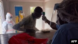 FILE - A suspected COVID-19 patient has his temperature taken as he is admitted at the isolation ward of Ministry of Health Infectious Disease Unit in Juba, South Sudan, April 24, 2020.