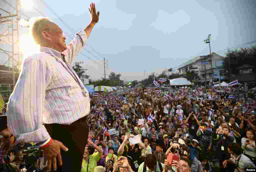 Protest leader Suthep Thaugsuban greets a crowd of anti-government protesters before making an address outside Government House in Bangkok, Dec. 9, 2013.