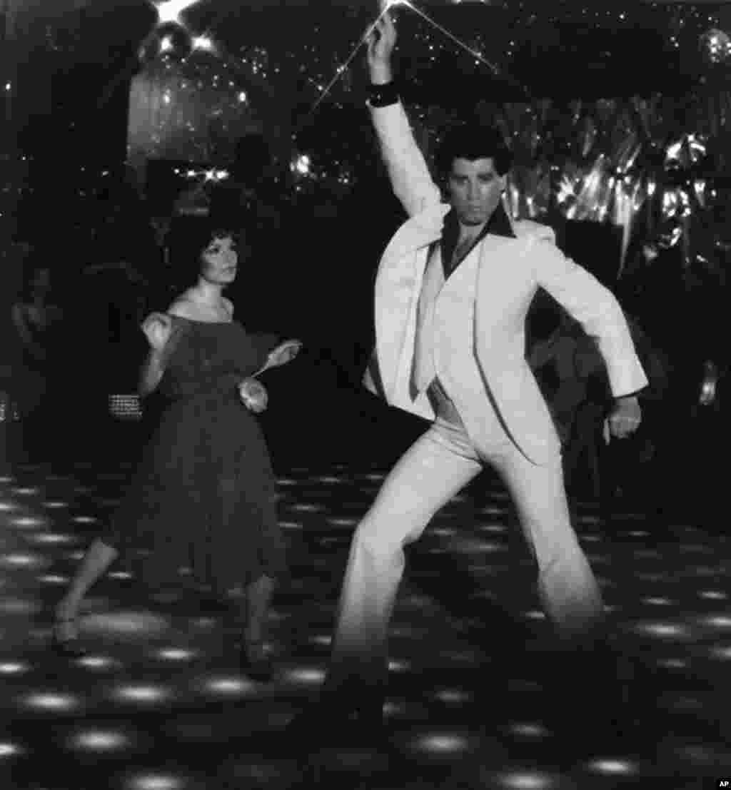 1977年美国影片《周末夜狂热》( "Saturday Night Fever")中男女主角剧照。演员约翰·特拉沃尔塔(John Travolta) 扮演男一号。这个歌舞片当年掀起了迪斯科舞蹈的热潮。它最近的豆瓣评分是7.8,有2608人打分。