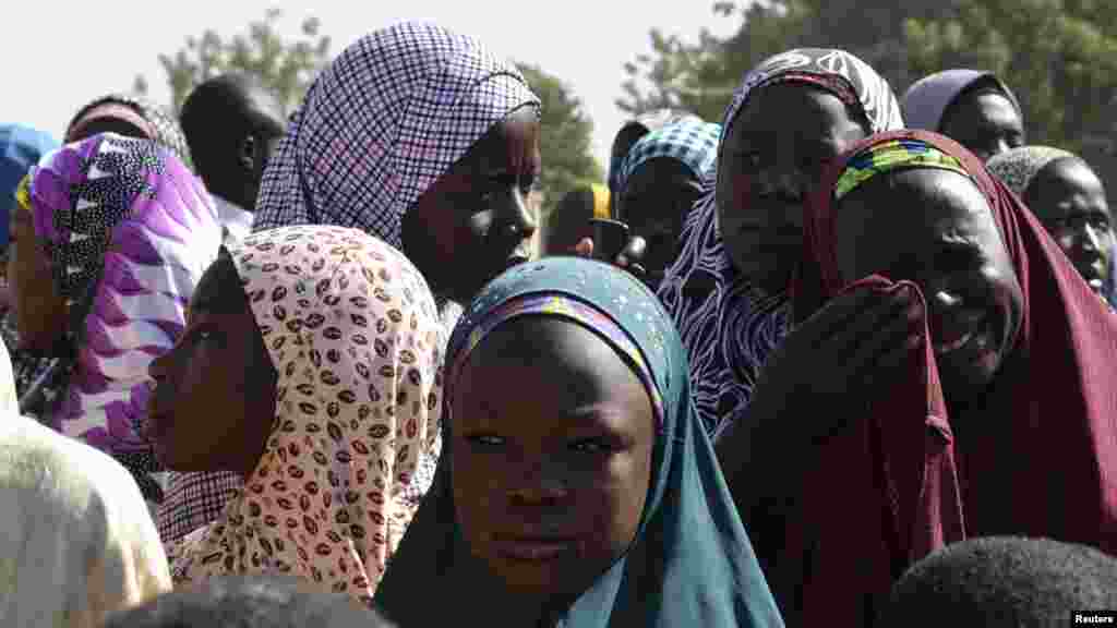 Wasu mutane kennan daga Gwoza, jihar Borno, da tashe-tashen hankula ya raba da gidajensu, suna taro a sansanin ‘yan gudun hijira a lokacin da gwamnan jihar Borno Kashim Shettima (babu hotonshi) a garin Mararaba Madagali, jihar Adamawa. Fabrairu 18, 2014.
