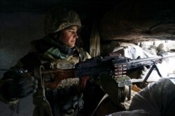 FILE - A Ukrainian soldier takes his position near the frontline with Russia-backed separatists, in Shyrokyne, eastern Ukraine, Nov. 28, 2018.