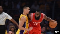 James Harden of the Houston Rockets (R) is guarded by Jeremy Lin #17 of the Los Angeles Lakers during the Lakers first regular season NBA game against the Houston Rockets, October 28, 2014 at Staples Center in Los Angeles, California. AFP PHOTO / Robyn B
