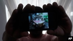 En esta foto del martes 21 de junio de 2022 en North Miami Beach, Florida, un migrante cubano que pidió no ser identificado por temores a la seguridad de su familia que vive en la isla, muestra una foto del bote rudimentario que fabricó para salir de Cuba junto a tres amigos.