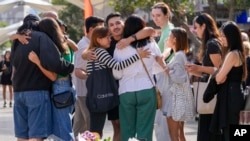 A group of people react after placing flowers as a tribute near a crime scene at Bondi Junction in Sydney, April 15, 2024, after several people were stabbed to death at a shopping on April 13. 