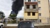 Shrapnel holes in a car as a building burns in the background after shelling by Azerbaijan's artillery during a military conflict in self-proclaimed Republic of Nagorno-Karabakh, Stepanakert, Azerbaijan, Oct. 4, 2020.