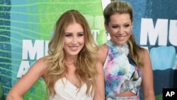 FILE - Tae Dye, right, and Maddie Marlow, of the musical group Maddie & Tae, arrive at the CMT Music Awards in Nashville, Tennessee, June 10, 2015.