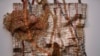 L'employé d'une Sotheby's regarde une sculpture créée par El Anatsui du Ghana à la vente d'art africain moderne et contemporain de Sotheby's à Londres, le 12 mai 2017