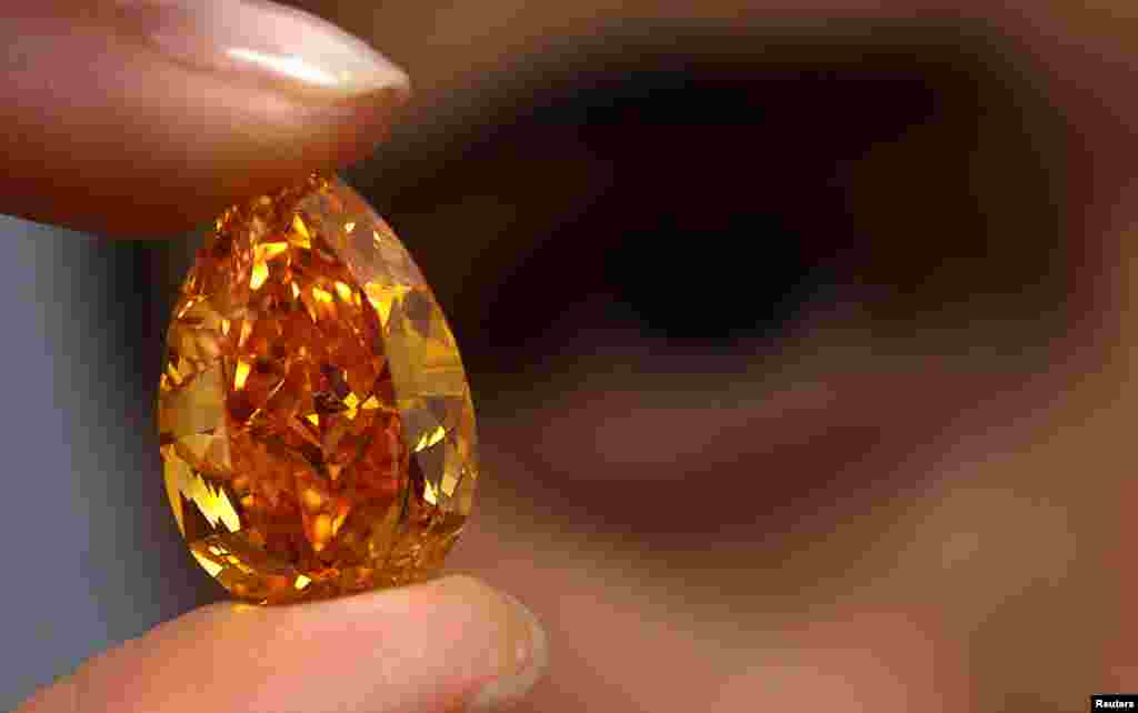 Seorang staff rumah lelang Christie memperlihatkan "The Orange", berlian berwarna oranye terbesar di dunia yang beratnya 14,82 karat dalam sebuah lelang di Jenewa, Swiss.