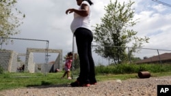FILE - A woman, who said she entered the United States illegally, watches over her daughter who was born in the U.S., in Sullivan City, Texas, Sept. 16, 2015.