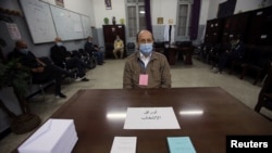 Un électeur portant un masque facial pour se protéger contre la maladie à coronavirus (COVID-19), dans un bureau où les Algériens votent lors du référendum constitutionnel à Alger, en Algérie, le 1er novembre 2020.