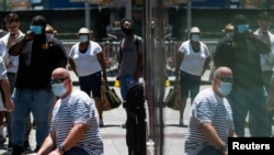 FILE - People wear masks to prevent the spread of coronavirus, as the delta variant has led to a surge in infections, in New York City, July 30, 2021. 