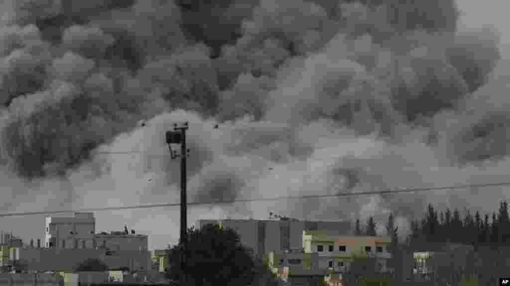 Thick smoke rises following an airstrike by the US-led coalition in Kobani, Syria as fighting intensified between Syrian Kurds and the militants of Islamic State group, as seen from Mursitpinar in the outskirts of Suruc, at the Turkey-Syria border, Sunday, Oct. 12, 2014.
