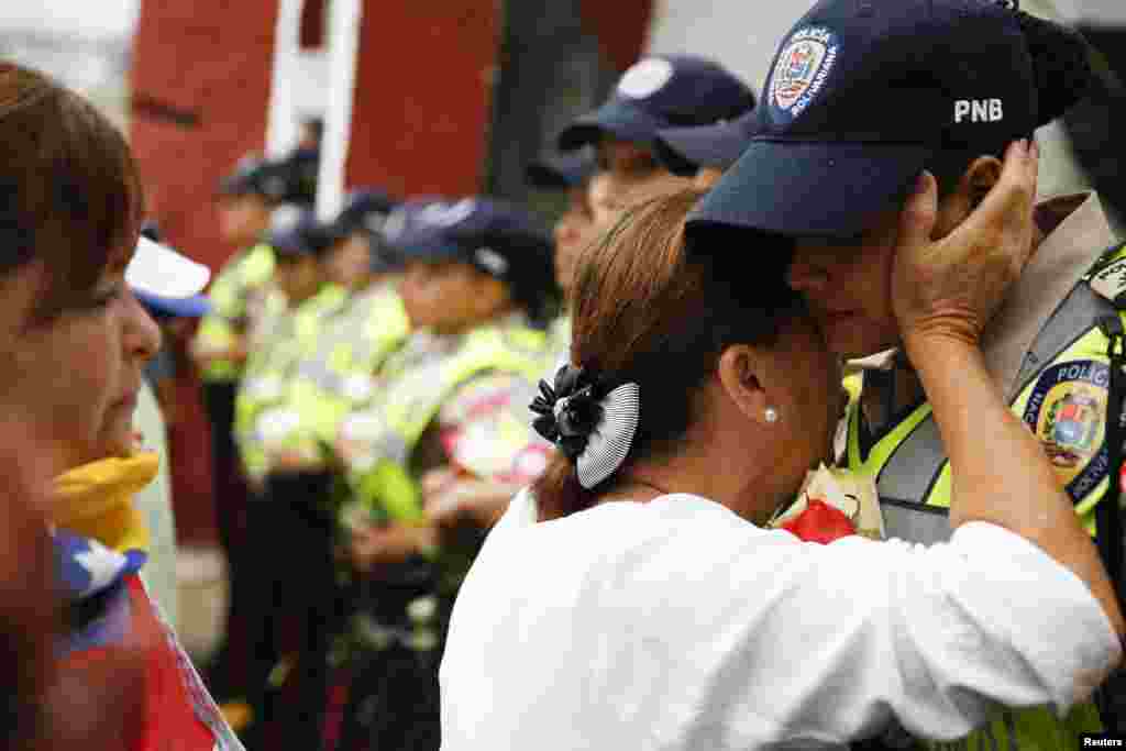 Una marcha de mujeres contra el gobierno de Nicolás Maduro en Venezuela, fue liderada por la opositora María Corina Machado. En la imagen, una mujer abraza a un agente del orden, en Caracas. 