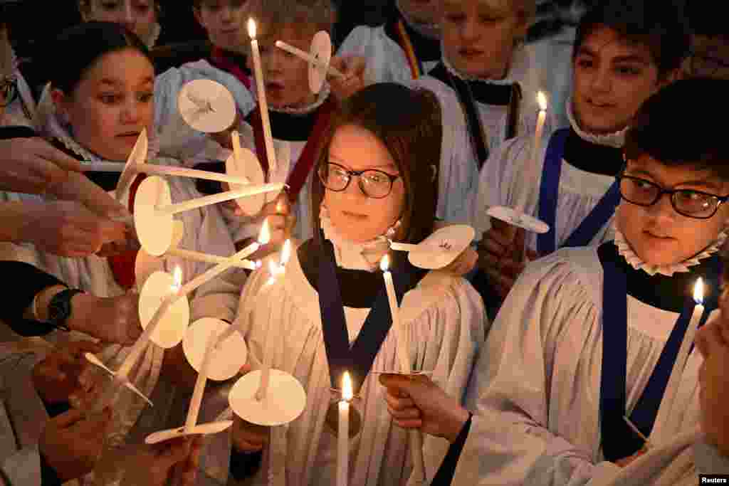 Choristers light candles during a rehearsal for Christmas services at St. Paul's Cathedral in London, Britain. St. Paul's choir includes girls for the first time in its 900-year history.