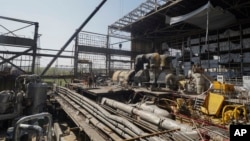 Trabajadores reparan una central térmica dañada, una de las más grandes del país, recientemente destruida por misiles rusos cerca de Kharkiv, Ucrania, el viernes 12 de abril de 2024. (Foto AP/Andrii Marienko)