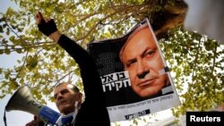 Protesters taking part in a rally in Tel Aviv hold signs calling upon Israeli Prime Minister Benjamin Netanyahu to step down, Feb. 16, 2018.
