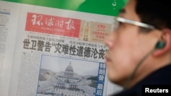 Seorang pria berdiri di depan koran Global Times yang menampilkan foto Gedung Capitol AS saat persiapan pelantikan Joe Biden menjadi Presiden AS. Koran itu dipajang di sebuah toko di Beijing, China, 21 Januari 2021.