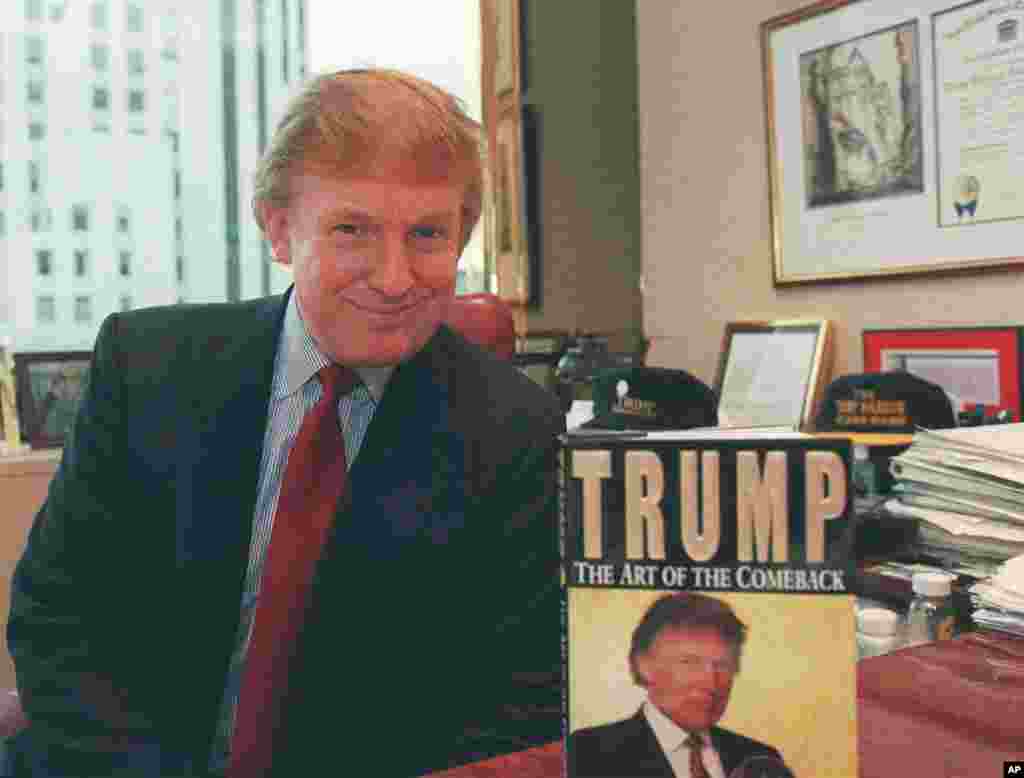 Donald Trump berpose di kantornya di Manhattan dengan bukunya, "Trump: The Art of the Comeback," tentang pengalamannya dari hampir bangkrut menjadi memiliki kekayaan pribadi US$1,4 miliar. (AP Photo/Emile Wamsteker)