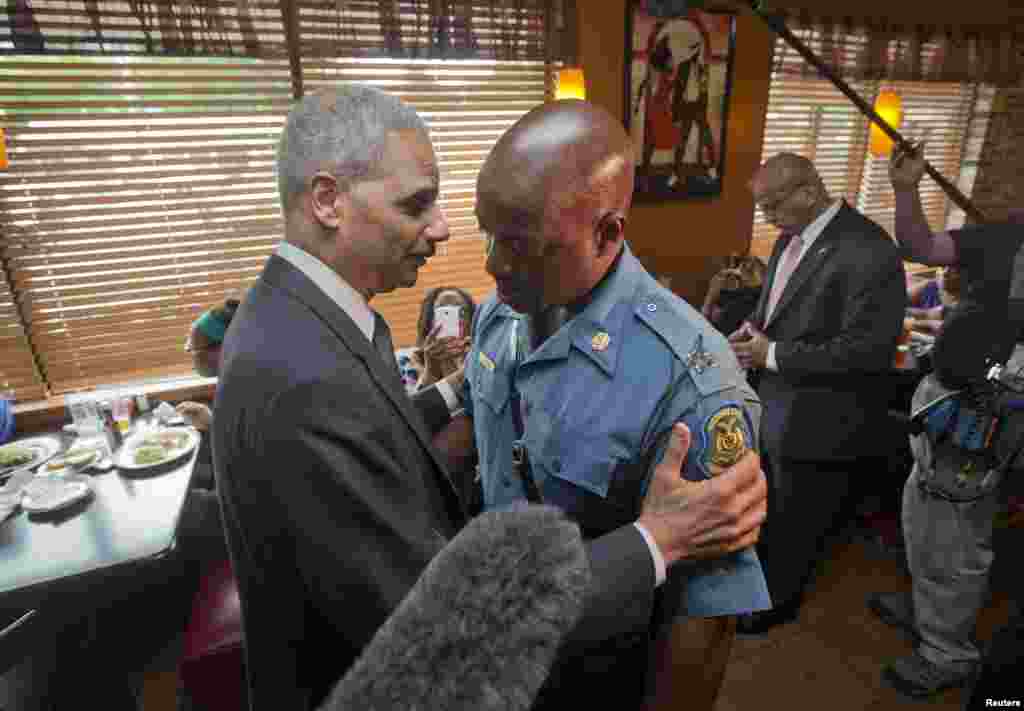Attorney General Eric Holder greets Capt. Ron Johnson of the Missouri State Highway Patrol at Drake's Place Restaurant in Florissant, Missouri Aug. 20, 2014.