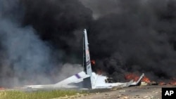Api dan asap hitam mengepul dari pesawat kargo Air National Guard C-130 setelah jatuh di dekat Savannah, Georgia, 2 Mei 2018.