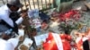 Warga Myanmar memanjatkan doa di lokasi di mana seorang demonstran tewas oleh pasukan keamanan dalam aksi protes di Yangon, Myanmar, Minggu (28/2). 