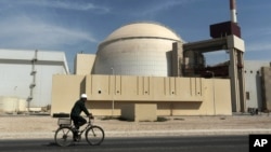 FILE - A worker rides in front of the reactor building of the Bushehr nuclear power plant, just outside Bushehr, Oct. 26, 2010. 