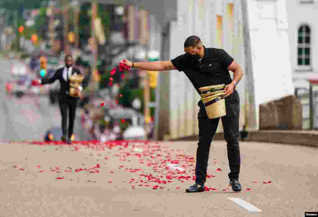 Personas de la funeraria Willie Watkins esparcieron pétalos de rosas que representan la sangre derramada el Domingo Sangriento en el puente Edmund Pettus, antes del inicio de la procesión del legislador estadounidense, el domingo 26 de julio. en Selma.