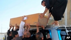 Un cercueil est chargé sur un véhicule avant un enterrement, à Bassora, en Irak le 26 septembre 2018. (AP Photo/Nabil al-Jurani)